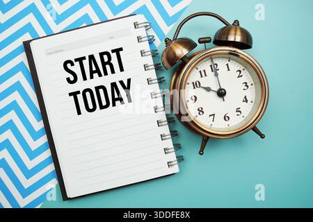 Beginnen Sie heute, Text auf Notizblock mit Wecker geschrieben Stockfoto