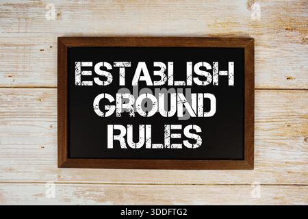 Der Text der Grundregeln wurde auf der Tafel geschrieben und lag auf hölzernem Hintergrund Stockfoto
