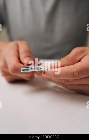 Vertikal geschnittene elektrische Hände, die moderne Datenkabel mit einem Schneidmesser aufteilen und innere Drähte freigeben, die für die Netzwerkeinrichtung und das Internet unerlässlich sind Stockfoto