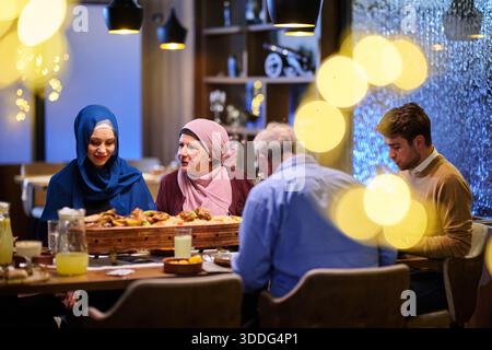Muslimische Familie genießt iftar zusammen in einem Restaurant während der Ramadanfeier mit traditioneller Dekoration Stockfoto