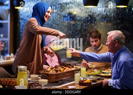 Die muslimische Familie genießt während des heiligen Monats iftar in einem Restaurant mit Ramadan-Dekoration Stockfoto