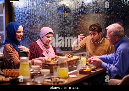 Die muslimische Familie genießt iftar zusammen in einem Restaurant mit Ramadan-Dekoration während des heiligen Monats Stockfoto