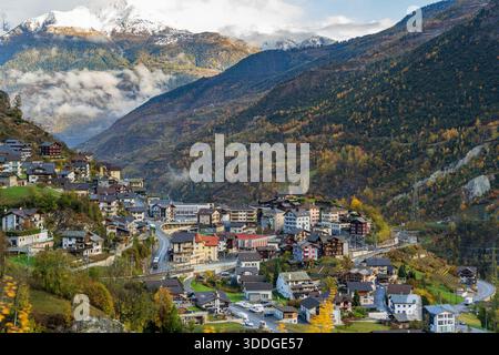 Staldener Dorf Herbstlandschaft Ende Oktober mit Brücken und verschneiten Bergen im Mattertal. Stalden, Kanton Wallis, Schweiz. Stockfoto