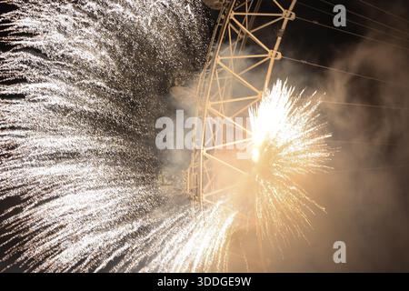 LONDON, UK – 31. Dezember 2025: Feuerwerk und eine große Lichtshow brechen aus dem London Eye aus, während sich die Menschenmassen entlang der Themse versammeln, um Silvester in der britischen Hauptstadt zu feiern. Tausende von Zuschauern säumten die Ufer, um die jährliche Mitternachtsausstellung zu beobachten, die das neue Jahr anläßlich des Jahres markiert. Stockfoto