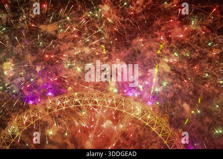 LONDON, UK – 31. Dezember 2025: Feuerwerk und eine große Lichtshow brechen aus dem London Eye aus, während sich die Menschenmassen entlang der Themse versammeln, um Silvester in der britischen Hauptstadt zu feiern. Tausende von Zuschauern säumten die Ufer, um die jährliche Mitternachtsausstellung zu beobachten, die das neue Jahr anläßlich des Jahres markiert. Stockfoto
