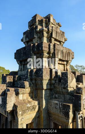 Der eckige Sandsteinturm des Tempels Ta Keo erhebt sich vor einem klaren blauen Himmel in Angkor, Kambodscha. Verwittertes Mauerwerk und scharfe geometrische Linien werden durch klares Sonnenlicht beleuchtet, was die alte Khmer-Architektur des Denkmals hervorhebt. Stockfoto