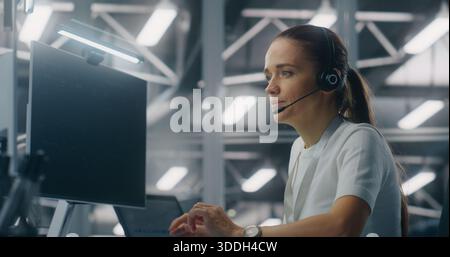 Weibliche Bedienerin, die technische Remote-Unterstützung während des Sprechens über das Headset bei der Einrichtung eines modernen Enterprise Control Center bereitstellt. Konzept für Kundenservice, Fehlerbehebung und Enterprise Support. Stockfoto