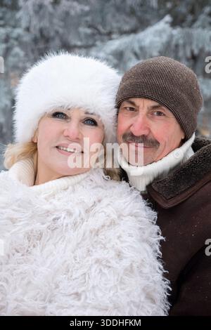 Ältere Ehepaare Genießen Snowy Walk, Lieben Senioren Im Snowy Forest Während Der Weihnachtszeit, Glückliches Älteres Ehepaar, Das Sich In Snowy Woods Umgibt Stockfoto