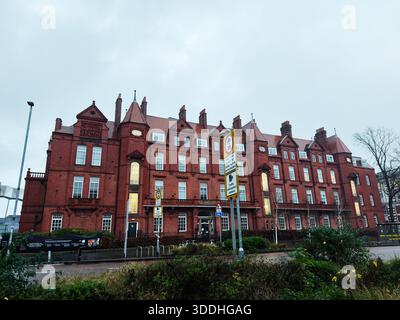 Manchester, Großbritannien - 06. Dezember 2025: Rotes Backsteingebäude in Manchester mit hohen Giebeln, klassischer Architektur und urbaner Präsenz. Stockfoto
