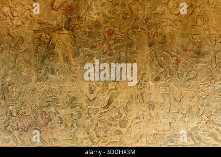 Das komplizierte Flachrelief aus Sandstein zeigt eine dynamische Schlachtszene auf der Ehrenterrasse von Angkor VAT. Die verwitterten Schnitzereien zeigen mehrschichtige Figuren, kunstvolle Kopfbedeckungen und strukturierte Oberflächen, die die Kunst der alten Khmer-Handwerkskunst zeigen. Stockfoto