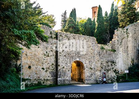 Die antike Porta di Docciola befindet sich in der mittelalterlichen Stadtmauer, gegenüber dem historischen Waschhaus des Fonte di Docciola in Volterra, Toskana, Italien Stockfoto
