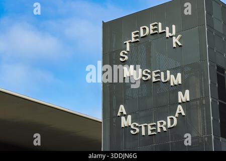 Moderne Architektur des Stedelijk Museums Amsterdam. Nahaufnahme der Fassade mit Logo-Text-Typografie vor blauem Himmel am Museumplein. Amsterd Stockfoto
