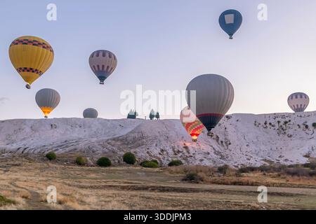 Acht bunte Heißluftballons fliegen in der Nähe des so genannten Baumwollschlosses in Pamukkale, Türkiye Stockfoto