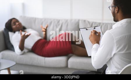 Psychotherapeut, der depressive afroamerikanische Patientin konsultiert und eine Therapiestunde in der Klinik hat Stockfoto