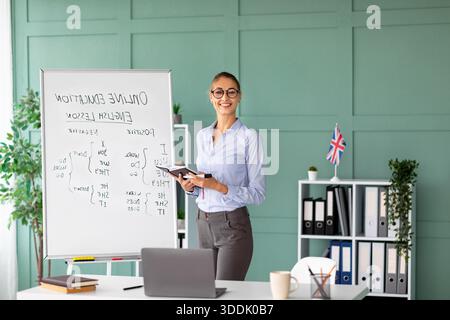 Die junge Lehrerin führt einen ansprechenden Englischunterricht über Grammatik in stilvoller Büroumgebung durch Stockfoto
