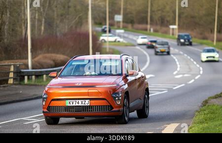 Milton Keynes, Bucks, Großbritannien - 15. Dezember 2025: 2024 oranges Hyundai Kona Elektroauto, das auf einer britischen Straße fährt Stockfoto