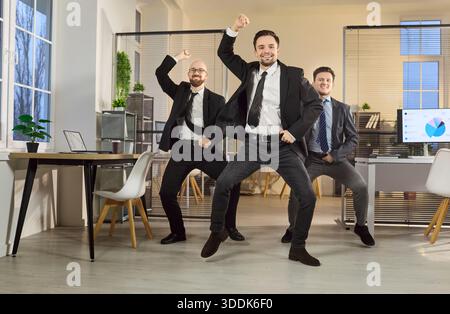 Glückliches Geschäftsteam aus Managern, das im modernen Büro tanzt und den Erfolg feiert Stockfoto
