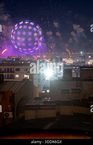 Am 31. Dezember 2025 in Belgrad, Serbien, bildet die glühende Drohnenkugel nachts über den Dächern von Belgrad gemusterte Lichter, mit Rauch, fernem Feuerwerk, Kran Stockfoto