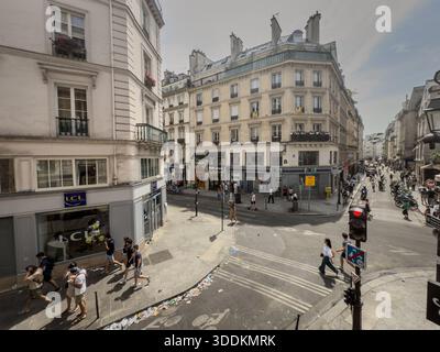 PARIS, FRANKREICH - 22. JUNI 2025: Straßenszene im Pariser Viertel Le Marais, Straßenecke mit Geschäften, Wohnhäusern. Le marais ist ein Distri Stockfoto