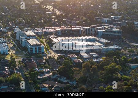 Melbourne, VIC, Australien. Dezember 2025. - Blick aus der Vogelperspektive auf das Burwood Brickworks Einkaufszentrum und moderne Wohngebäude, umgeben von Sonne Stockfoto