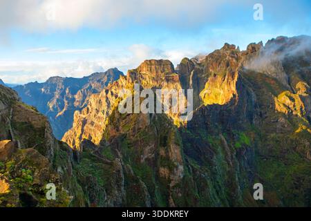 Atemberaubende Berglandschaft Pico do Arieiro in Madeira, Portugal, schroffe Gipfel und Wanderweg über Wolken. Morgensonne dramatisch Stockfoto