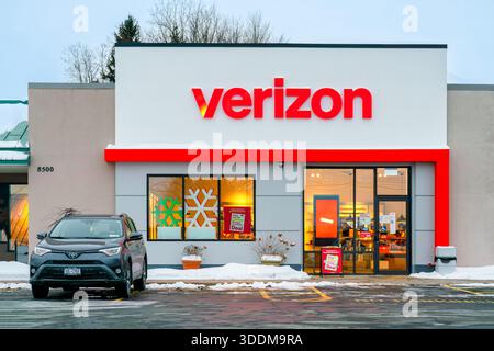New Hartford, NY – 28. Dezember 2025: Verizon, ein US-Telekommunikationsunternehmen, das 2000 gegründet wurde, wurde mit Weihnachtsschildern und schneebedeckten Geschäften im Einzelhandel gezeigt Stockfoto
