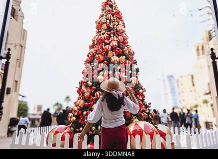 Weibliche Reisende genießt Weihnachtsbaumschmuck auf dem Dubai Festmarkt VAE Stockfoto