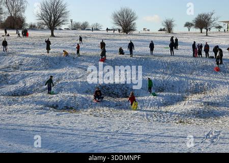 Epsom Downs Surrey, Großbritannien. Januar 2026. Der erste Schnee im Jahr 2026. Nächtlicher Schneefall hinterließ eine gute weiße Decke auf Epsom Downs. Mit Familien, die in der Nähe der Tribüne Schlitten fahren. Quelle: Julia Gavin/Alamy Live News Stockfoto