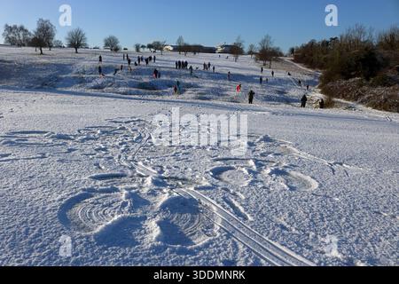 Epsom Downs Surrey, Großbritannien. Januar 2026. Der erste Schnee im Jahr 2026. Nächtlicher Schneefall hinterließ eine gute weiße Decke auf Epsom Downs. Mit Familien, die Schlitten fahren und Schneeengel in der Nähe der Tribüne machen. Quelle: Julia Gavin/Alamy Live News Stockfoto