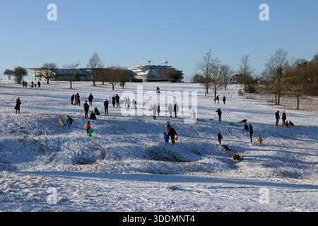 Epsom Downs Surrey, Großbritannien. Januar 2026. Der erste Schnee im Jahr 2026. Nächtlicher Schneefall hinterließ eine gute weiße Decke auf Epsom Downs. Mit Familien, die in der Nähe der Tribüne Schlitten fahren. Quelle: Julia Gavin/Alamy Live News Stockfoto