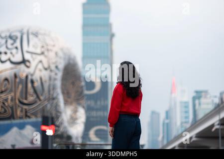 Blick auf das Museum der Zukunft mit Touristen und Dubai Metro, Sheikh Zayed Road Hochhäuser Stockfoto