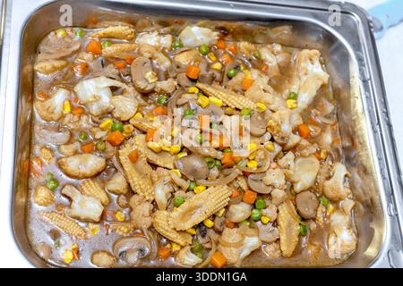Herzhafte Gemüsebrühe mit Pilzen, Blumenkohl und Babymais in herzhafter Sauce Stockfoto