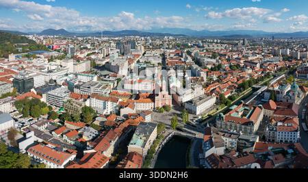 Aus der Vogelperspektive treffen die Terrakotta-Dächer auf den Fluss Ljubljanica, mit der rosa Fassade der Franziskanerkirche, die sich vom Stadtbild Ljubljana, Stockfoto