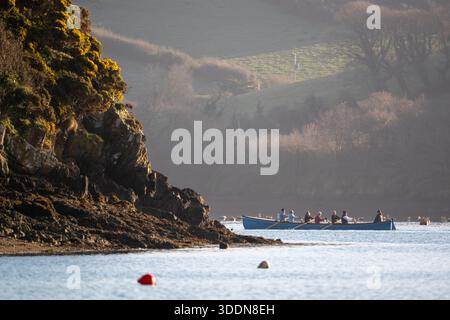 Die Crew vom Salcombe Mündungsruderclub geht auf einen Morgenausflug in ihrem Gig-Ruderboot mit wunderschönem Morgenlicht. Stockfoto