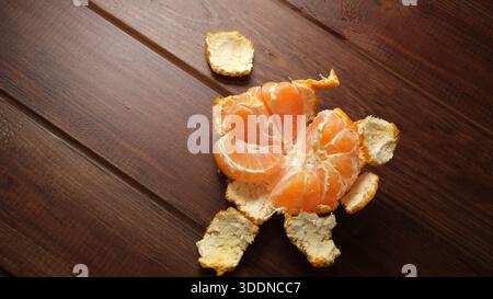 Saftige Orangensegmente liegen auf einer rustikalen Holzoberfläche und laden zu einem leckeren Leckerbissen ein. Stockfoto