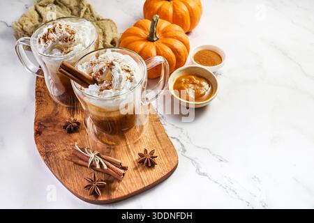 Zwei Kürbis-Gewürzlattes mit Schlagsahne und Zimt Stockfoto