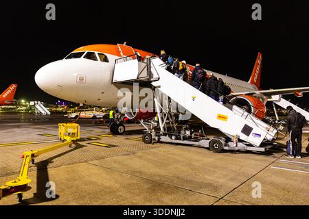 Passagiere, die nachts am Flughafen Gatwick in ein easyJet Airbus-Flugzeug einsteigen. Stockfoto