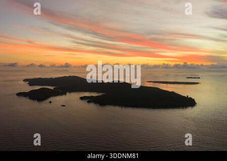 Ein beschaulicher und farbenfroher Sonnenaufgang bildet die Fam Islands in Raja Ampat, Indonesien. Dieses tropische Gebiet bietet eine spektakuläre Meeresvielfalt. Stockfoto