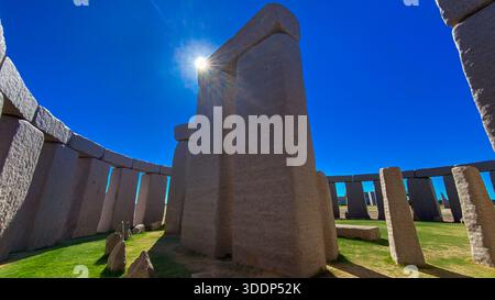Ein Weitwinkelblick auf eine Nachbildung von Stonehenge zeigt ihre antiken Steine unter einem sonnigen Himmel, was ihre historische Bedeutung unterstreicht. Stockfoto