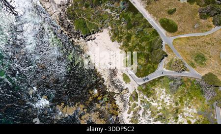 Ein Blick aus der Vogelperspektive zeigt die zerklüftete Küste, wo das Meereswasser auf Sandstrände und grüne Vegetation trifft und die natürliche Schönheit unterstreicht. Stockfoto