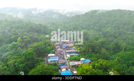 Blick aus der Vogelperspektive auf das Dorf San Cipriano, eingebettet in den üppigen grünen Dschungel von Valle del Cauca, Kolumbien, umgeben von Nebel und Natur. Stockfoto