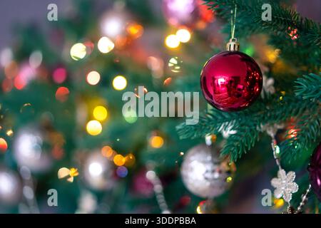 Weihnachtsbaum mit farbenfrohen Dekorationen und heller Beleuchtung Stockfoto