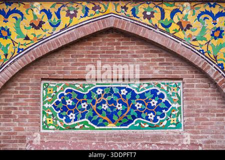 Buntes Mosaik aus kashi-Kari- oder Fayence-Fliesen mit floralem und geometrischem Design auf der Wazir Khan-Moschee aus der alten mogul-Ära in Lahore, Stadtmauern in Punjab, Pakistan Stockfoto