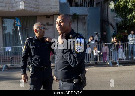 Nazareth, Israel, 25. Dezember 2025, zwei uniformierte Polizisten standen während einer öffentlichen Veranstaltung auf einer Straße, mit Zuschauern hinter Barrieren in der Stockfoto