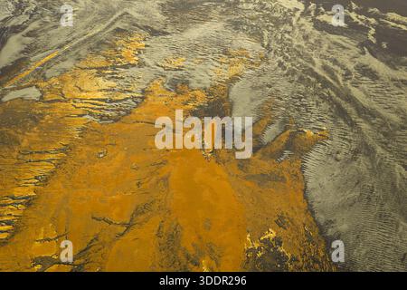 Aus der Vogelperspektive des starken Kontrastes zwischen der goldenen Erde und den dunklen, eisigen Flüssen entsteht eine dramatische, außerirdische Landschaft, Südisland, Icel Stockfoto