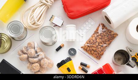Notwendigkeiten für Notfalltasche auf hellem Hintergrund, Draufsicht Stockfoto