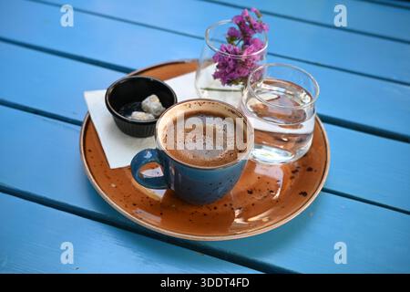 Nahaufnahme einer Tasse türkischen Kaffee mit Zucker und einem Glas Wasser auf einem Tablett in einer Bar in Istanbul, Türkei Stockfoto