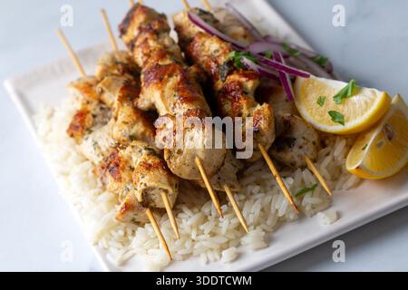 Hähnchenshish Kebab oder griechisch gegrillte Hähnchenspieße – Hühnersouvlaki serviert mit Zitrone Stockfoto