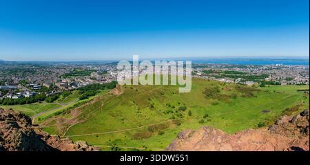 Panoramablick auf Edinburgh vom Wanderweg zum Gipfel von Arthur's Seat, Salisbury Crags im Vordergrund, heller sonniger Tag, Schottland Stockfoto