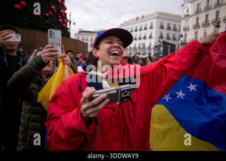 Madrid, Spanien. Januar 2026. Eine venezolanische Frau, die in Madrid lebt und eine venezolanische Flagge um den Hals trägt, lächelt während einer Feier in der Innenstadt Madrids, nachdem US-Präsident Donald Trump angekündigt hatte, dass der venezolanische Präsident Nicolas Maduro gefangen genommen und aus dem Land vertrieben worden sei. Quelle: SOPA Images Limited/Alamy Live News Stockfoto
